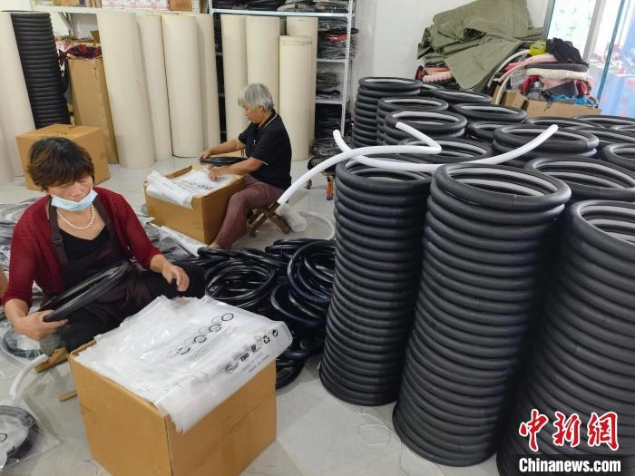 圖為村民在汽車飾品企業(yè)生產(chǎn)車間中工作?！巫雍?攝
