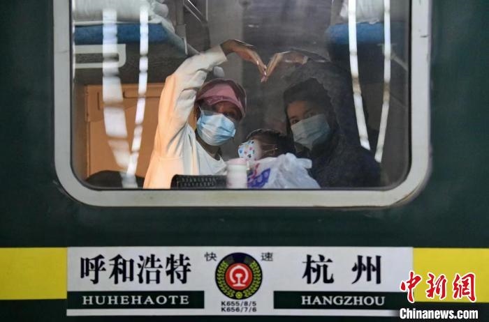 圖為登上轉(zhuǎn)運火車的游客向額濟納比心。　王磊 攝
