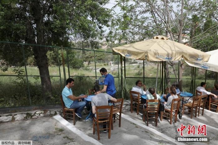 資料圖：希臘雅典，人們在一家露天咖啡享用飲品。