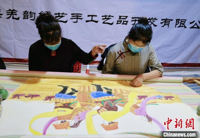 圖為皮繡藝人在市集上“秀”指尖技藝?！●R銘言 攝