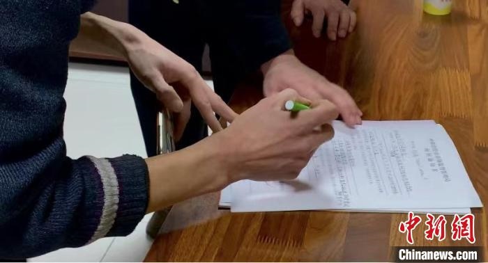 圖為現(xiàn)場下達詢問通知書。　李婷婷 攝