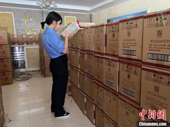 資料圖為檢察人員核對查獲的假冒品牌白酒。青海省人民檢察院供圖