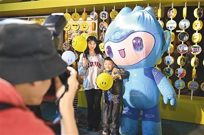 5月7日，在浙江省杭州市湖濱步行街“3D笑臉墻”前，攝影師為游客與杭州亞運會吉祥物之一“宸宸”拍攝合影。