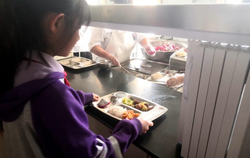 伊金霍洛旗第一小學(xué)學(xué)生正在打飯，今天的飯菜是三菜一湯外加水果，學(xué)生可以多次盛取，吃飽為止。人民網(wǎng)記者 孫博洋攝