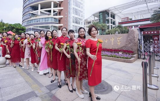 6月7日一早，廈門雙十中學考生家長們身穿旗袍，手拿向日葵在考場外為孩子加油打氣，寓意“旗開得勝，一舉奪魁”。人民網(wǎng)記者 陳博攝
