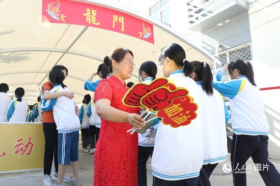 6月7日一早，雄安新區(qū)安新中學老師在給同學們加油鼓勁兒。人民網(wǎng) 李兆民攝