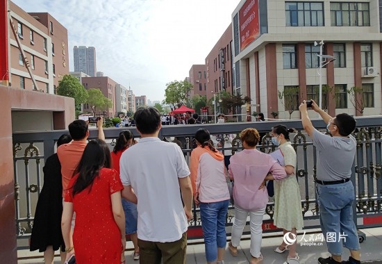 6月7日，武漢市第三中學考點，考生進場后，家長在柵欄外用手機拍攝自己的孩子。人民網(wǎng)記者 郭婷婷攝