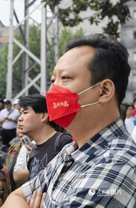 6月7日早，在武漢市第二十六中學考點外，送考家長戴著印有“金榜題名”的口罩。人民網(wǎng) 周雯攝