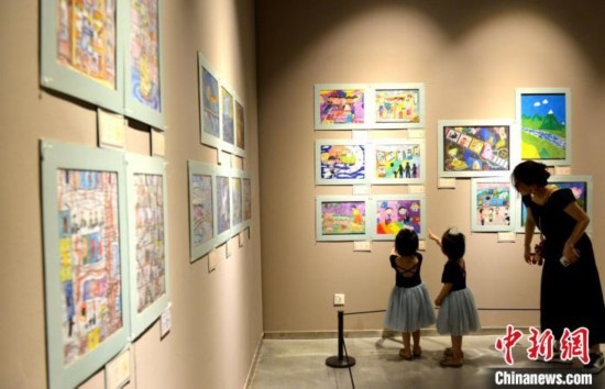 圖為家長帶著孩子參觀展覽。呂明 攝
