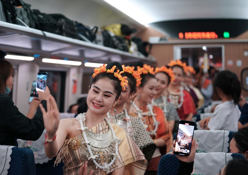 2023年4月13日，老撾工作人員在D887次國際旅客列車上表演。當(dāng)日，中老鐵路從中國昆明南站、老撾萬象站雙向?qū)﹂_D887次和D888次國際旅客列車，兩地乘火車可當(dāng)日通達(dá)。中老鐵路是高質(zhì)量共建“一帶一路”的標(biāo)志性工程。新華社記者 邢廣利 攝