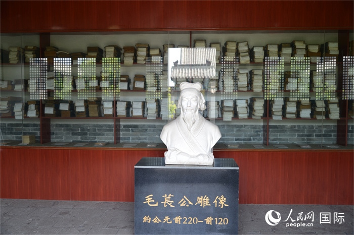 河間詩經齋毛萇雕像。雕像后書櫥中陳列的是歷代各版本《詩經》及譯本。 人民網 趙昭攝