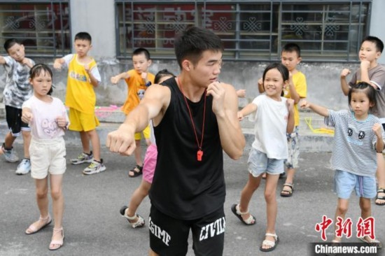 圖為大學(xué)生志愿者在組織孩子們參加體育健身活動(dòng)。廖光福 攝