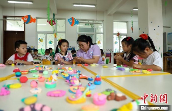 在肥西縣山南鎮(zhèn)中心幼兒園，孩子們?cè)诶蠋煹闹笇?dǎo)下做彩色泥塑。陳家樂(lè) 攝