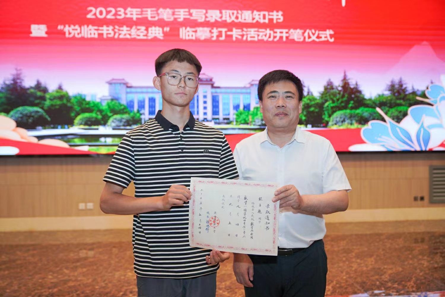 陜西師范大學(xué)黨委書記李忠軍為2023級(jí)新生代表張占彪同學(xué)發(fā)放錄取通知書。校方供圖