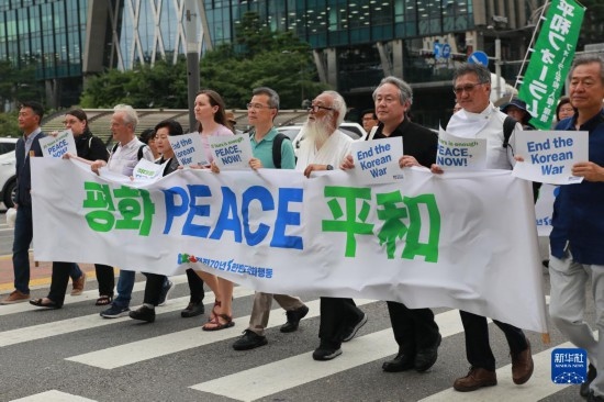 7月22日，在韓國首爾，人們手舉標(biāo)語參與反戰(zhàn)游行。新華社發(fā)（楊暢 攝）