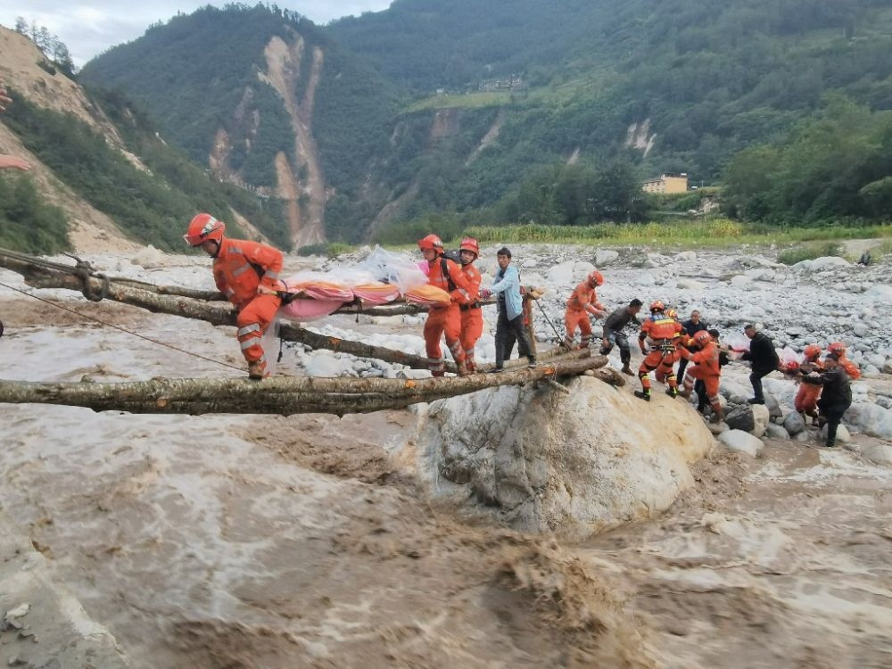 ↑2022年9月5日，武警四川總隊(duì)機(jī)動(dòng)第二支隊(duì)官兵在甘孜州瀘定縣磨西鎮(zhèn)磨子溝村搭建臨時(shí)木橋轉(zhuǎn)移被困群眾（手機(jī)照片）。新華社發(fā)（洪福樂 攝）