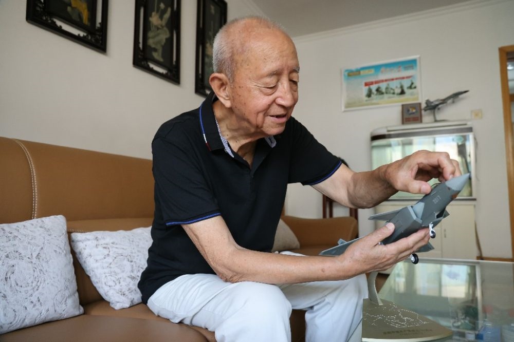 ↑2023年7月24日，新中國(guó)第一代飛行員陶偉在家中擦拭殲-20飛機(jī)模型。新華社發(fā)（張瑞 攝）