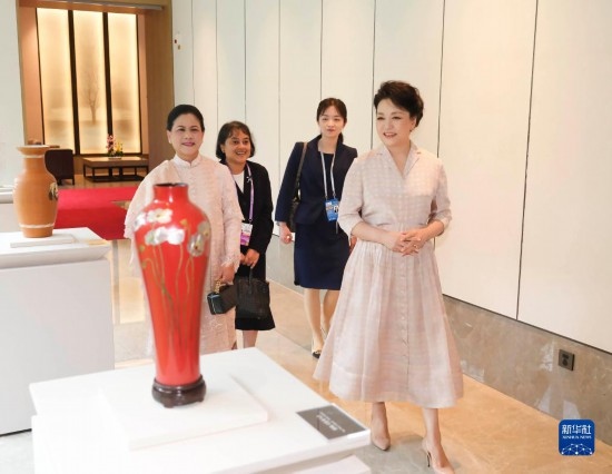 7月27日下午，國(guó)家主席習(xí)近平夫人彭麗媛在四川成都會(huì)見陪同印度尼西亞總統(tǒng)佐科來華出席第31屆世界大學(xué)生夏季運(yùn)動(dòng)會(huì)開幕式并訪華的總統(tǒng)夫人伊莉亞娜。這是彭麗媛和伊莉亞娜欣賞成都特色非遺工藝品。新華社記者 丁林 攝