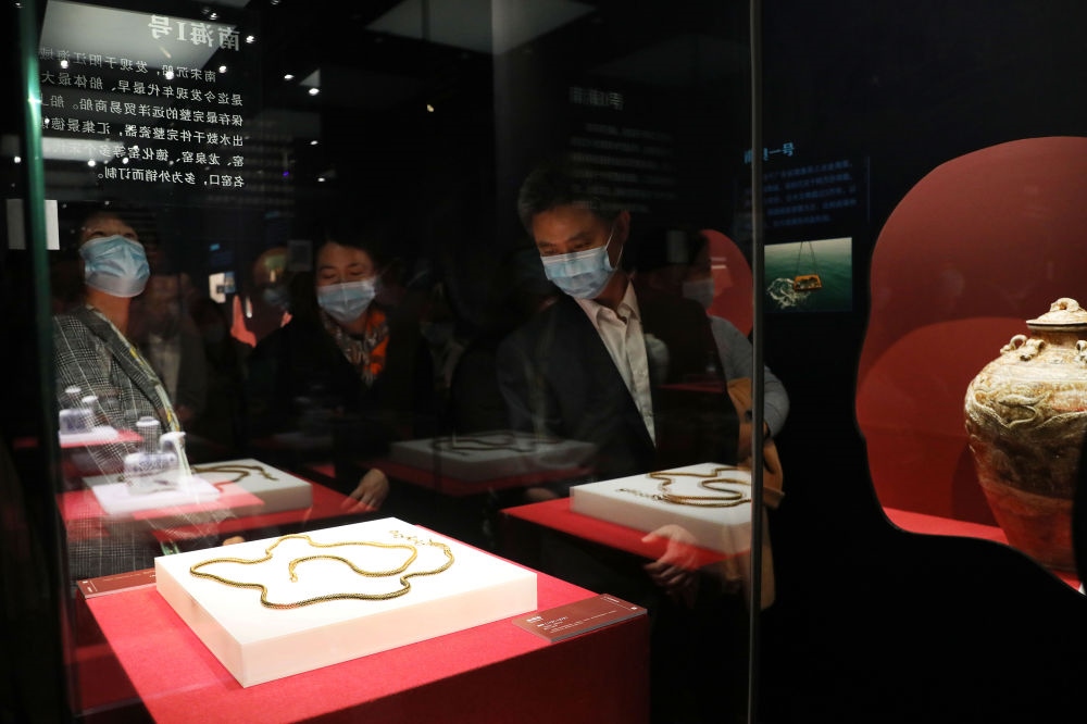 參觀者在上海臨港新城的中國航海博物館航海文物展上的“南海一號”出水的宋代金項飾展柜前駐足觀看（2020年12月28日攝）。新華社記者 方喆 攝