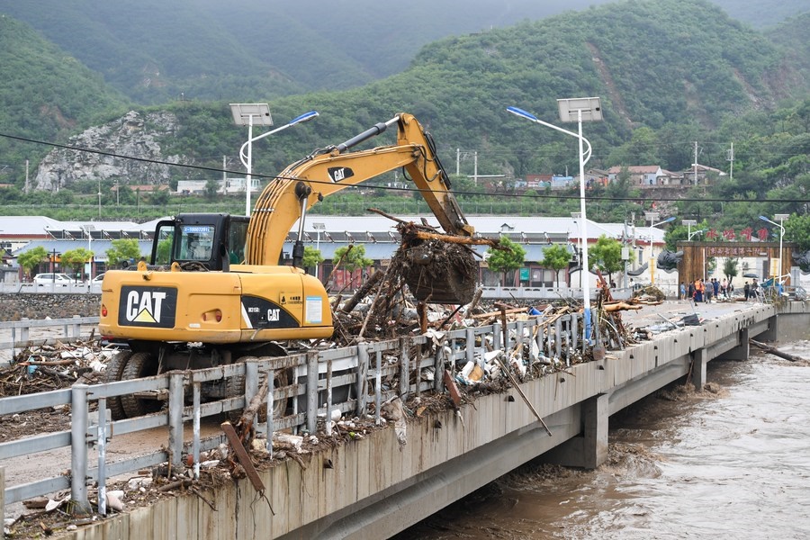 8月1日，在北京市門頭溝區(qū)水峪嘴村村口，一臺挖掘機在清理阻斷橋梁交通的雜物。目前該條道路已經(jīng)疏通完成。新華社記者 鞠煥宗 攝