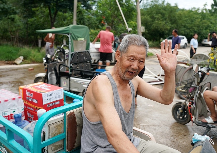 8月5日，從安置點回來的北京市房山區(qū)青龍湖鎮(zhèn)口頭村村民高大爺領(lǐng)到生活物資準備回家。新華社記者 張晨霖 攝