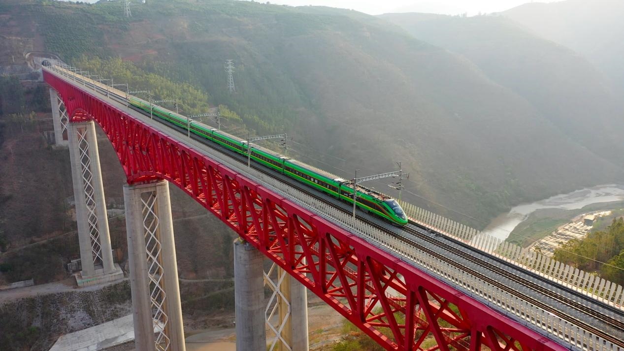 中老鐵路國際旅客列車在云南省境內(nèi)的元江特大橋上飛馳。姚巍攝