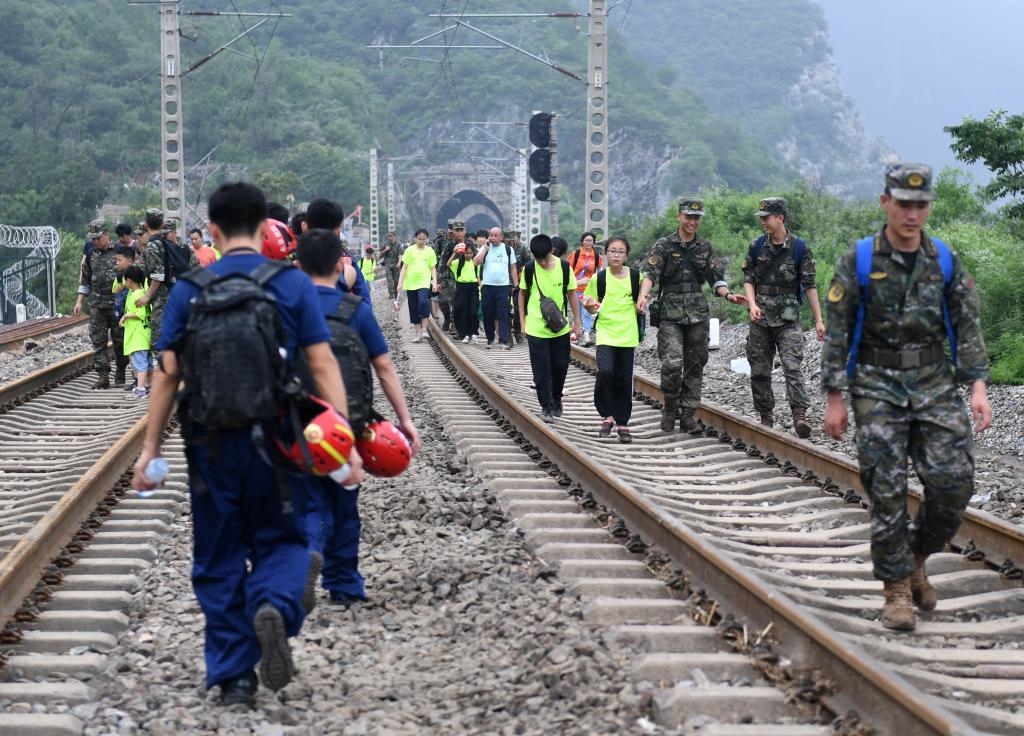 8月2日，部分滯留在北京市門(mén)頭溝山區(qū)受困列車的旅客，在救援人員幫助下前往轉(zhuǎn)運(yùn)客車。新華社記者張晨霖 攝