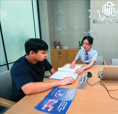 在杭州市臨安區(qū)政務(wù)服務(wù)中心的“為企服務(wù)中心”，黨員志愿者（右）解答企業(yè)主的疑問(wèn)（2023年7月7日攝）。徐昱攝/本刊