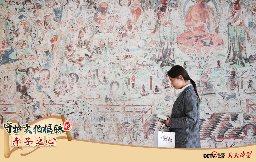 2023年4月25日，敦煌研究院文物數(shù)字化保護團隊創(chuàng)意營銷人員廖雪婷從一幅高保真復制壁畫前走過。