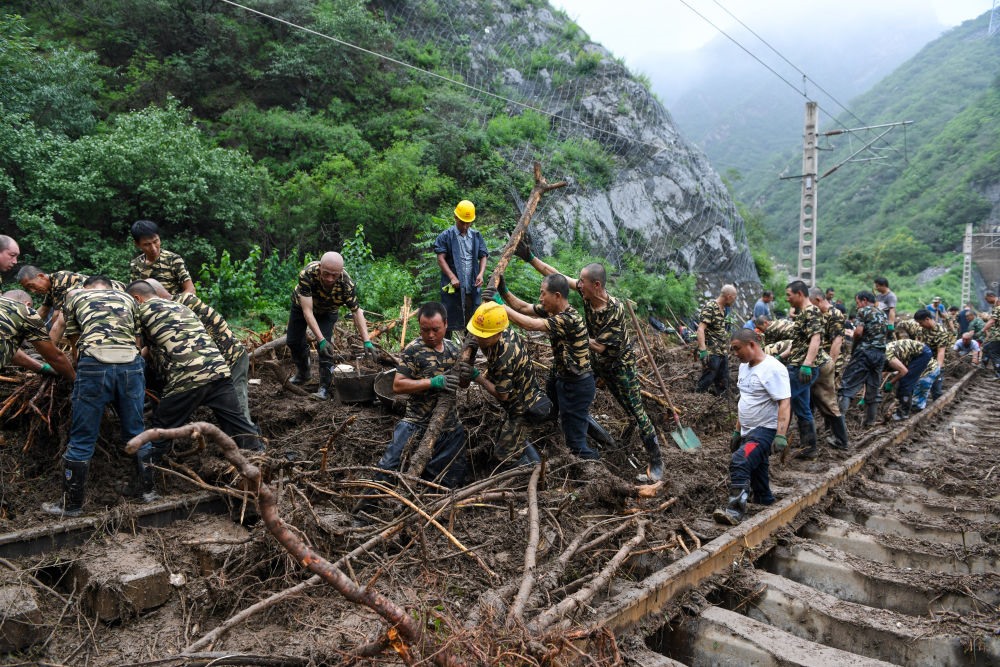 8月1日，在北京市門頭溝區(qū)水峪嘴村附近一段被阻斷的鐵路線上，中鐵六局工作人員在清理軌道上的雜物，全力恢復交通。新華社記者 鞠煥宗 攝