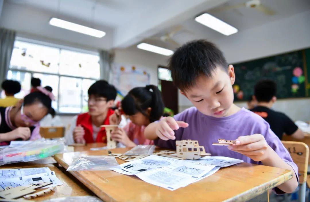 △今年7月，在浙江余姚市舜北小學(xué)暑托班內(nèi)，孩子們制作太陽能科學(xué)實驗裝置。