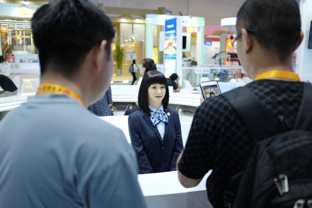 9月1日，媒體記者在國家會議中心與服務(wù)機器人互動。新華社記者 劉夢琪 攝