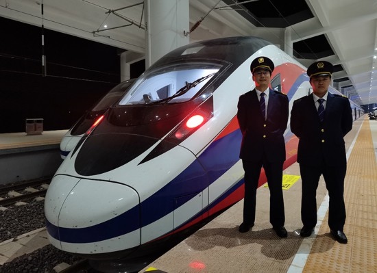 劉銀能（右一）與中國師父鄔俊鴻在動車組前合影。受訪者供圖