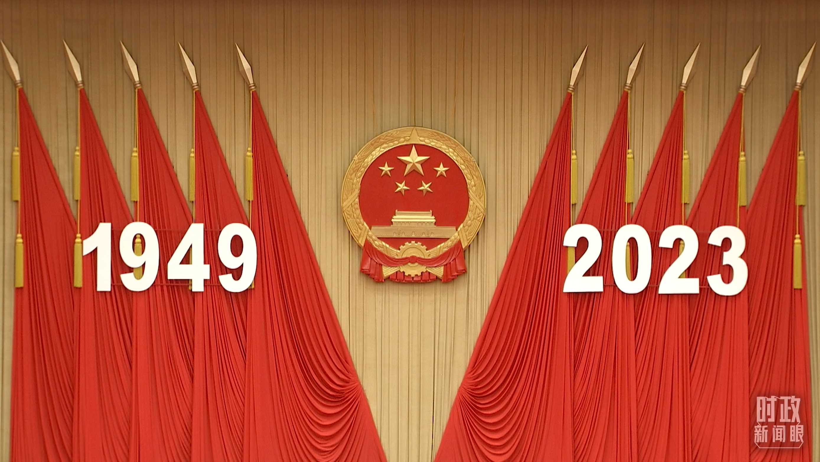 △人民大會堂宴會廳內(nèi)，主席臺上方高懸著莊嚴的國徽，“1949－2023”大字年號在鮮艷的紅旗映襯下格外醒目。