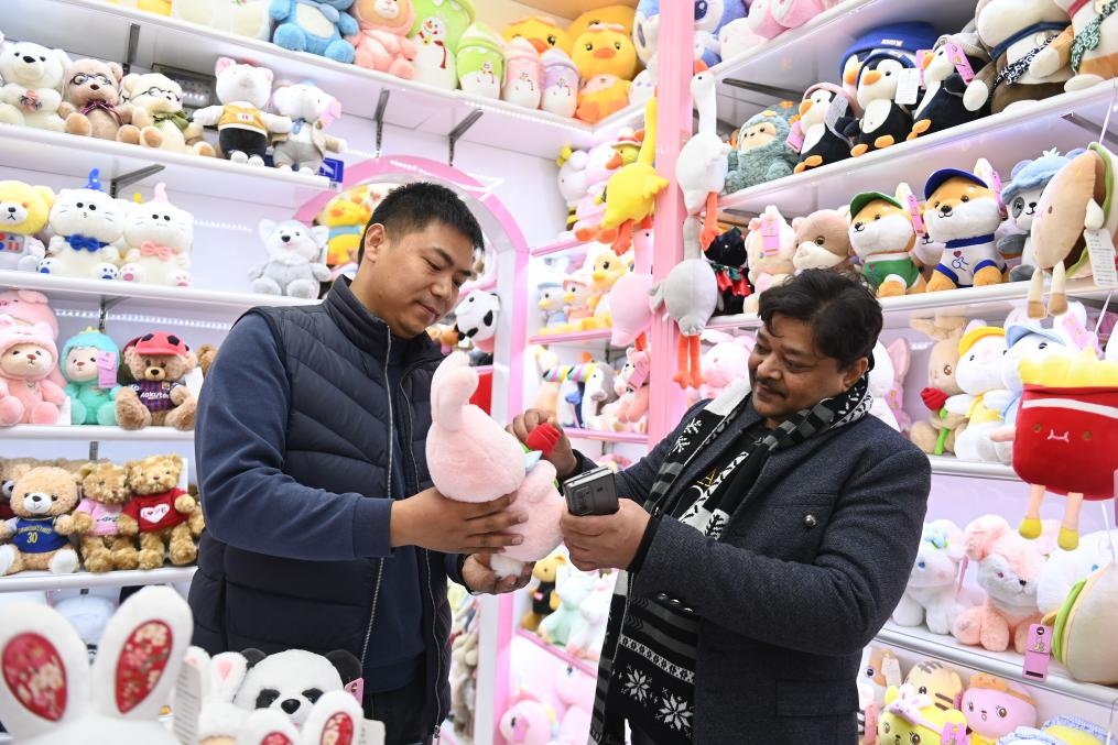 2023年2月2日，來自印度的客商（右）在義烏國際商貿(mào)城的一家玩具店鋪內(nèi)選購商品。新華社記者 黃宗治 攝