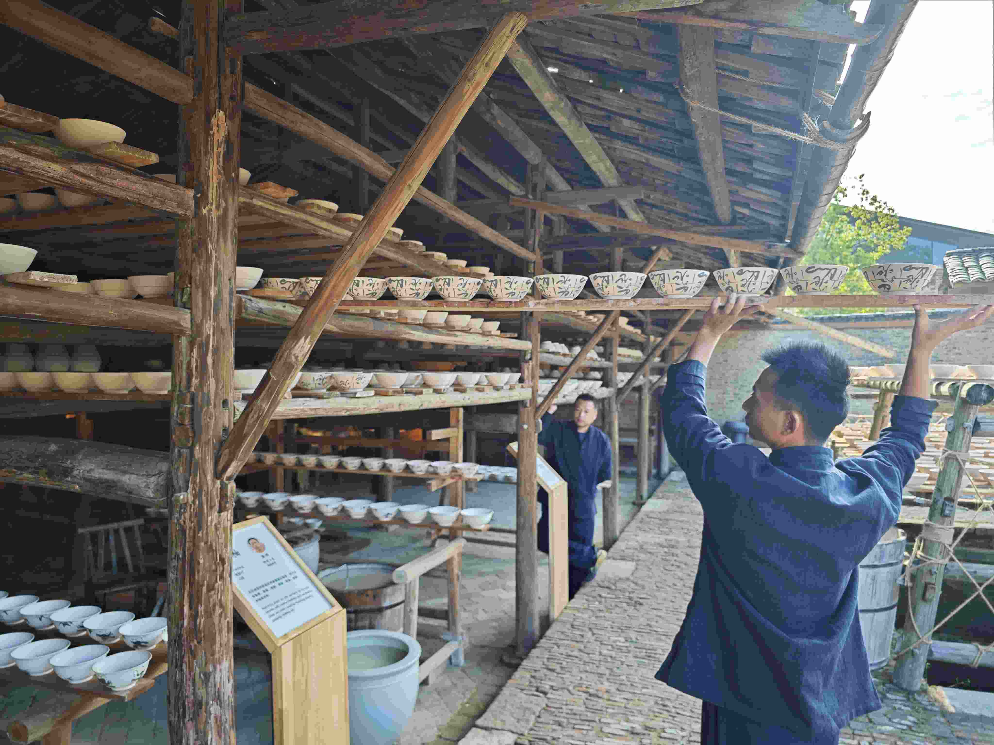 △陶陽里歷史文化街區(qū)里，工匠將陶瓷工藝品放到架上晾干。（總臺央視記者彭漢明拍攝）