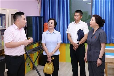 圖③：“小公民法律課堂”開講前，全國人大代表殷其龍（右二）、重慶市人大代表李自玲（左二）聽取楊家坪中學(xué)負責人關(guān)于未成年人思想教育工作情況的介紹。