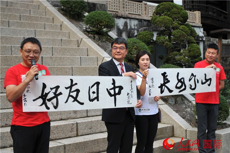 東京中國(guó)文化中心主任羅玉泉展示其為本次活動(dòng)書寫的題詞“中日友好，山高水長(zhǎng)”。人民網(wǎng) 蔣曉辰攝