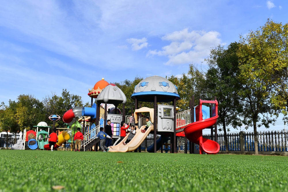 在山東省東營市墾利區(qū)楊廟社區(qū)幼兒園，孩子們在老師的帶領下進行戶外活動（2021年10月19日攝）。新華社記者 郭緒雷 攝