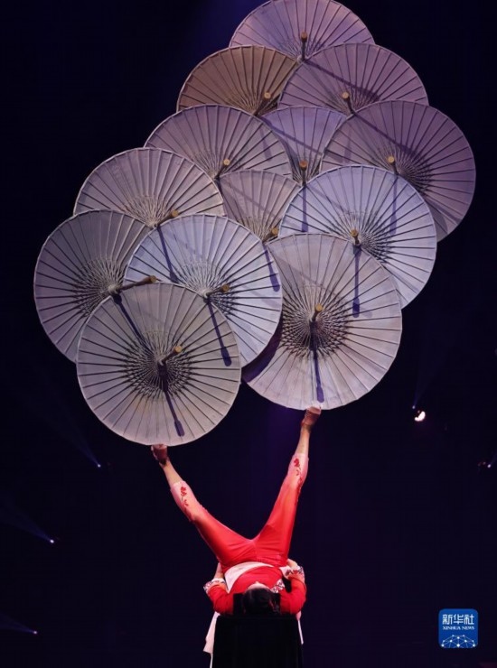 12月8日，演員在法國(guó)巴黎舉行的中國(guó)雜技“奇妙之夜”演出上表演《蹬傘》。新華社記者 高靜 攝