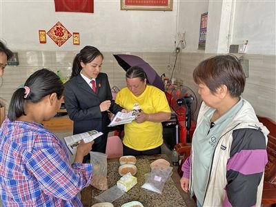  圖⑤：龍圩區(qū)法院法官到群眾家中開展法治宣傳。資料圖片