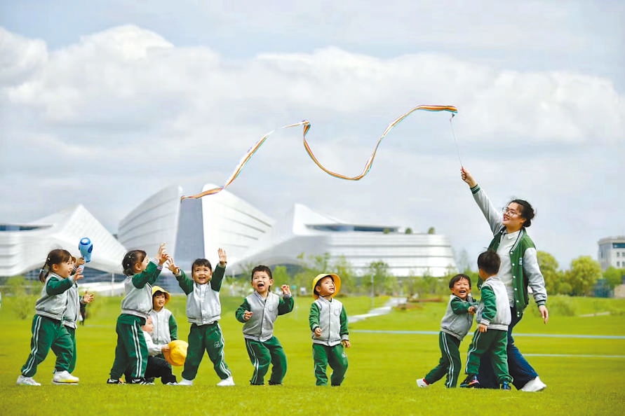  童心飛揚 在浙江衢州市智慧新城草坪公園，一名幼兒園老師揮舞彩帶，與孩子們一起玩耍。衢州市柯城區(qū)將兒童友好理念融入城區(qū)整體規(guī)劃，努力為兒童成長創(chuàng)造更好的發(fā)展環(huán)境，提升兒童和家庭的獲得感、幸福感、安全感。 衢州市柯城區(qū)某幼兒園哥倫比亞籍教師 莉莉安娜·雷斯特雷波·埃斯皮諾薩攝 “我和家人都很喜歡在衢州生活，這是一座兒童友好城市，有很多兒童營地和戶外活動場所。我看到孩子們在幼兒園、戶外非?？鞓返赝嫠＃阌孟鄼C記錄下這美好時刻。”