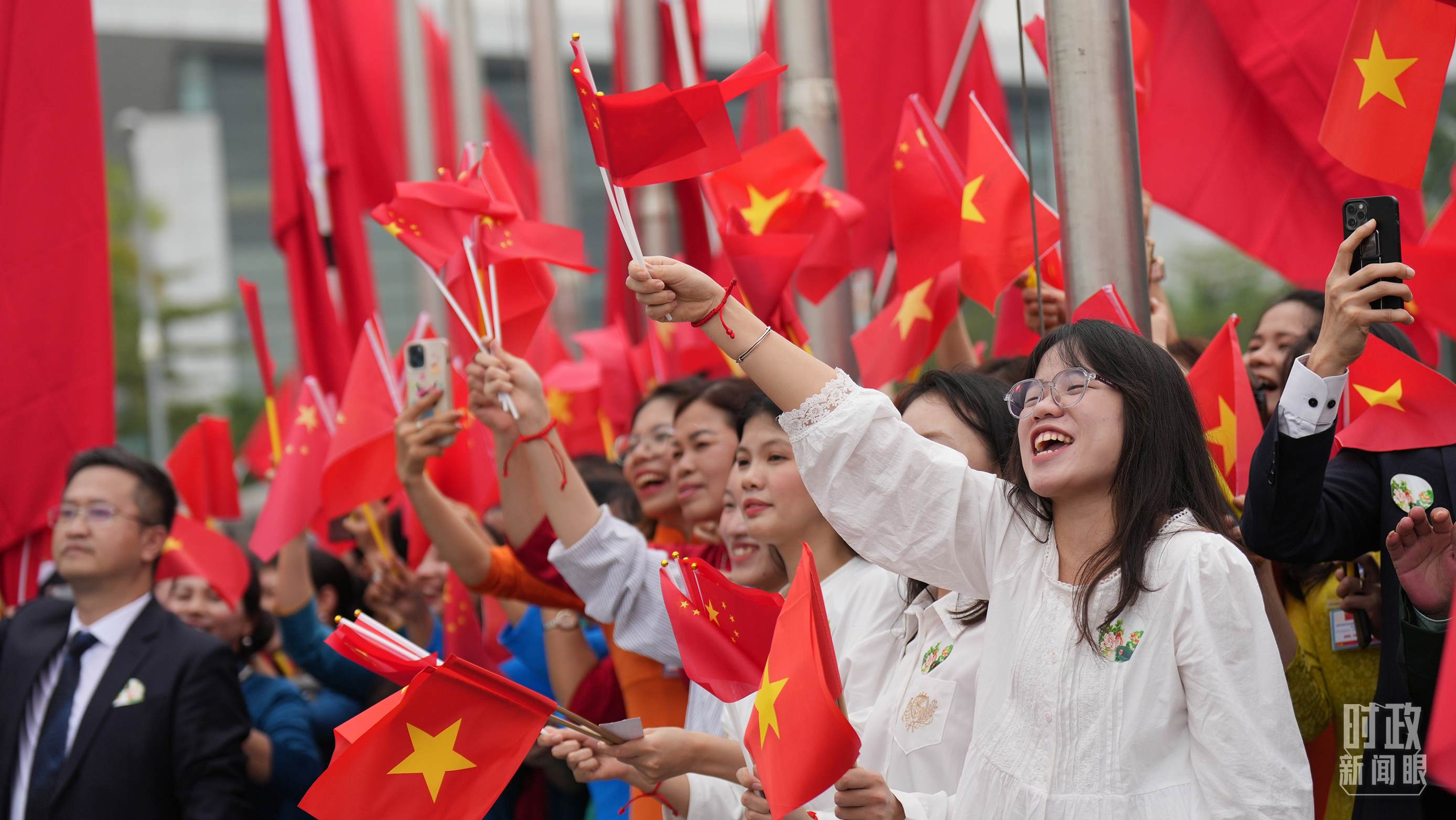 △人們揮舞兩國旗幟歡迎習(xí)近平訪越。（總臺國廣記者李晉拍攝）
