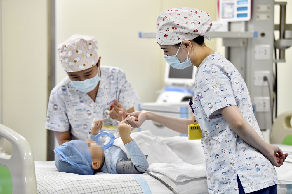 在山東省棗莊市婦幼保健院兒童ICU病房，醫(yī)護人員為完成靶向治療藥物諾西那生鈉的4歲脊髓性肌萎縮癥患兒加油鼓勁（2022年1月1日攝）。諾西那生鈉注射液是我國首個獲批治療脊髓性肌萎縮癥的進口藥物，2019年進入中國市場時，每針價格近70萬元。在2021年國家醫(yī)保目錄藥品談判中，以3.3萬元每針的價格進入新版醫(yī)保藥品目錄。新華社記者 郭緒雷 攝