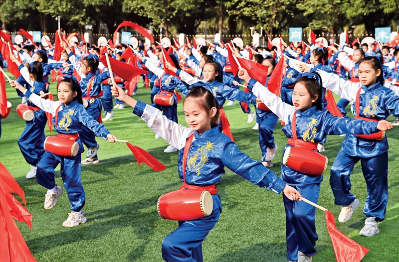 為助推民族地區(qū)基礎(chǔ)教育事業(yè)發(fā)展，廣西重新核定各地中小學(xué)教職工編制，依托全區(qū)編制“周轉(zhuǎn)池”核增事業(yè)編制給各地中小學(xué)，在全面達(dá)到國家標(biāo)準(zhǔn)的基礎(chǔ)上，進(jìn)一步統(tǒng)籌優(yōu)化和動態(tài)調(diào)整各區(qū)域、學(xué)校、學(xué)段間編制資源。圖為2023年11月29日，南寧市濱湖路小學(xué)舉行主題為“逐夢新時(shí)代 健體向未來”的體育文化節(jié)，孩子們正在跳腰鼓舞。 新華社記者 周華/攝