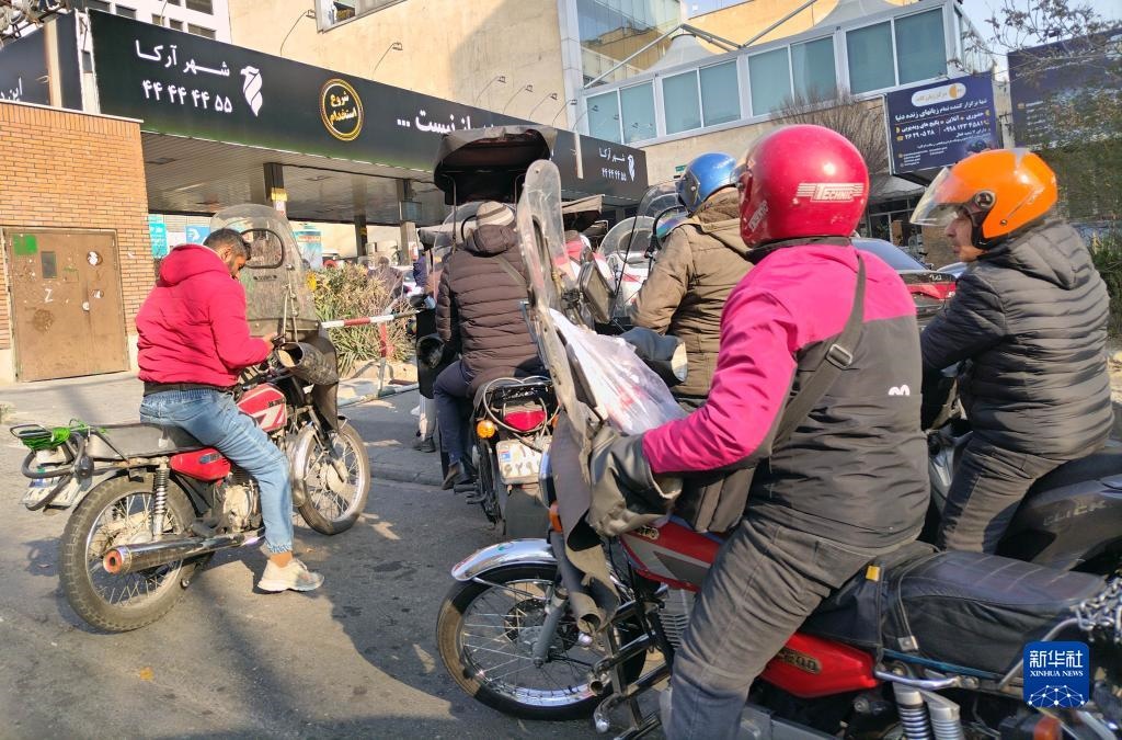 12月18日，摩托車(chē)在伊朗首都德黑蘭的一家加油站外等待加油。新華社記者 沙達(dá)提 攝