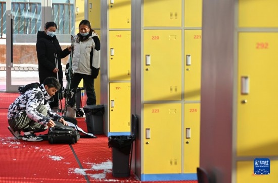 12月21日，游客在滑雪服務(wù)大廳整理滑雪裝備。