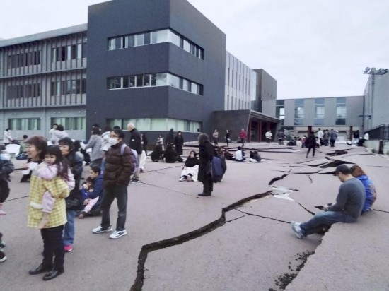  1月1日，在日本石川縣輪島市，人們站在被地震破壞的地面上。新華社/共同社