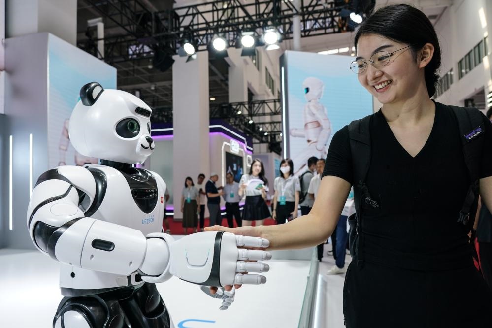 2023年8月16日，一名女士在北京舉辦的2023世界機器人大會現(xiàn)場與智能機器人握手。新華社記者彭子洋攝