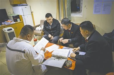 圖②：法官向船長(zhǎng)講解相關(guān)法律規(guī)定，查看船舶資料，并與船方辦理扣押船舶的手續(xù)。